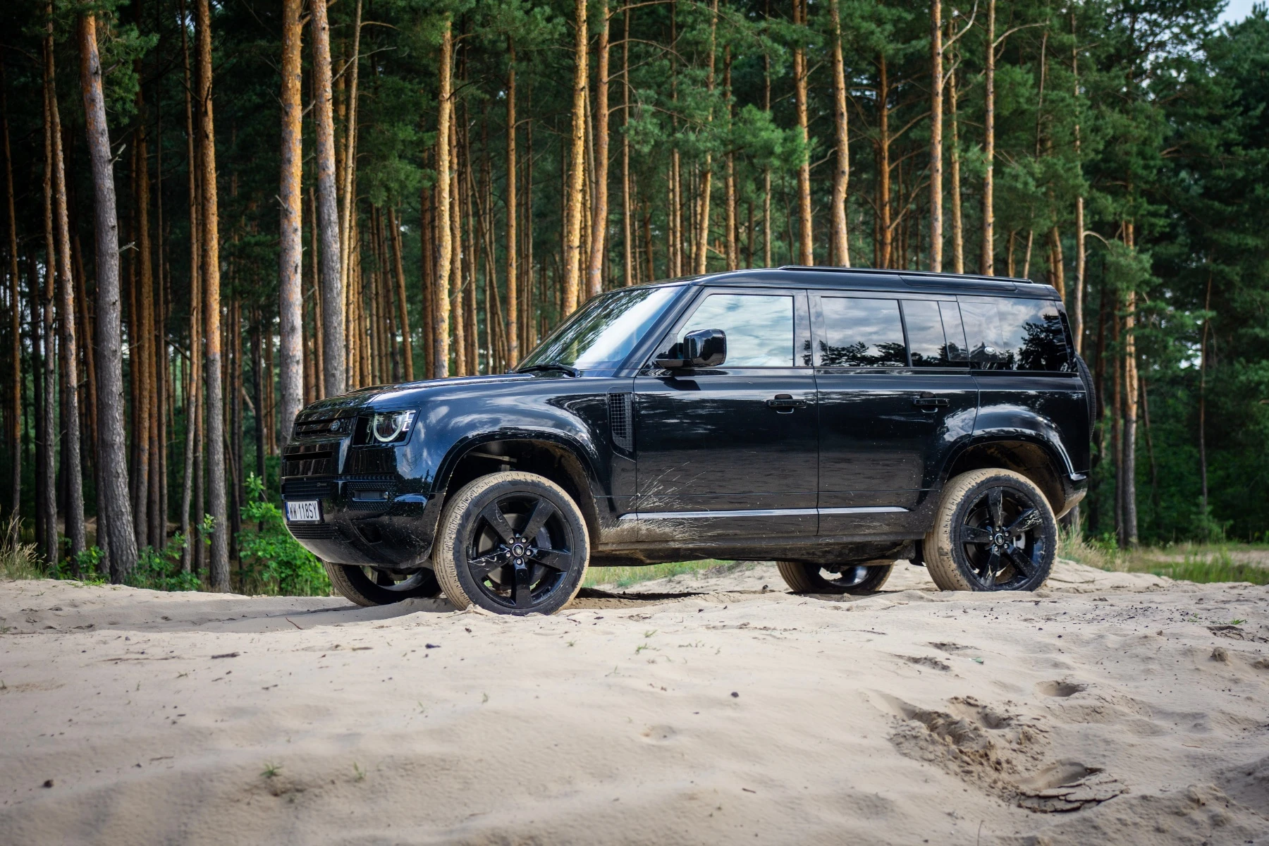 Nowy Land Rover Defender pod operą i w piasku. Jest dzielny, ale ma za małe serce