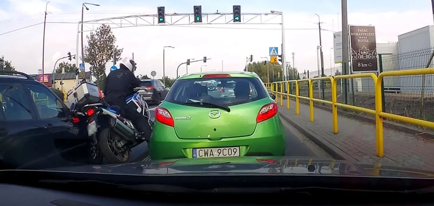 omijanie motocyklem stojących samochodów